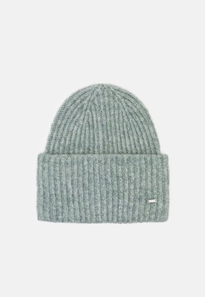 Grijze gebreide muts met geribbelde textuur en omgeslagen boord met een klein metalen merkembleem op een witte achtergrond.