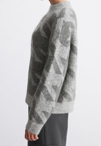 Gray knitted sweater with a soft, fuzzy texture; features a geometric pattern in darker gray, long sleeves, and a round neck.
