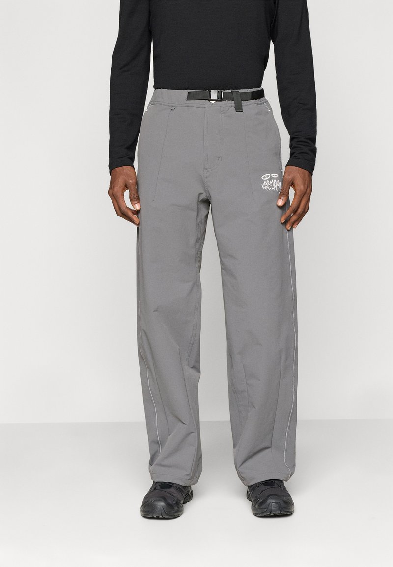 Sive hlače iz lahkega materiala imajo ravno krojenje, ojačane šive, črn pas in belo grafiko na levi nogi.