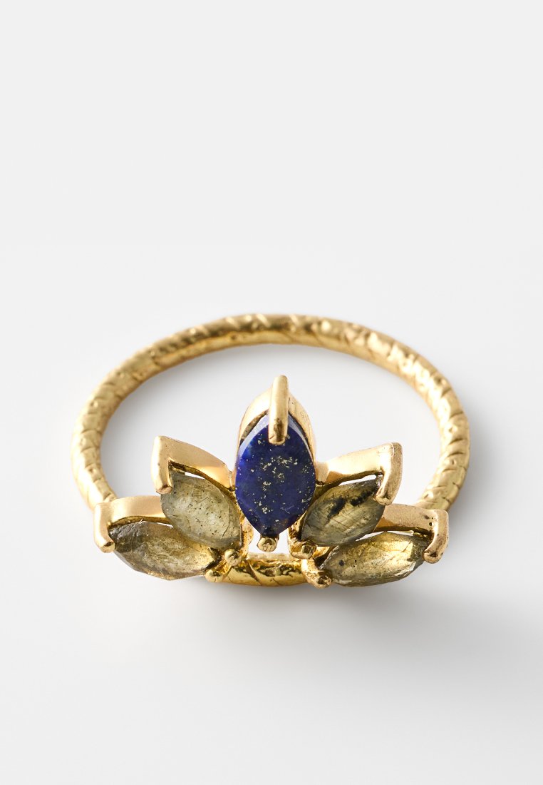 Goldring mit einem gedrehten Band, das einen zentralen blauen Lapislazuli-Stein und goldene blütenblattähnliche Akzente aufweist, die mit strukturierten Details versehen sind.