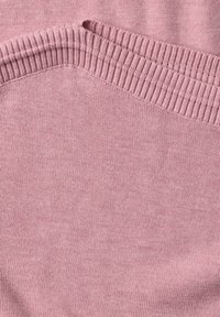 Gros plan sur un tissu tricoté rose doux avec un détail d'encolure côtelée.