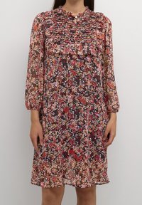 Květinové šaty s kulatým výstřihem, skládacím vzorem a třičtvrtečními rukávy. Mají černý základ s růžovými, oranžovými a žlutými květinami.