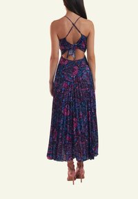 Maxi dress in purple and blue floral pattern, with a back cutout and tie detail. Features adjustable crossed straps and a flowing silhouette.