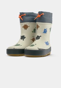 Bottes de pluie pour enfants avec semelles grises, poignets bleus, cordons de serrage orange, et imprimés de monstres colorés et ludiques sur fond beige.