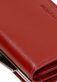 Rood leren portemonnee met een gladde textuur, metalen sluiting en gegraveerd logo. Het ontwerp heeft een vouw-over stijl met schone randen.