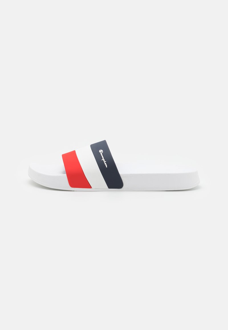 Sandalinha branca de slide com uma tira larga em vermelho, branco e azul-marinho. Material de borracha lisa; sola plana sem textura visível.