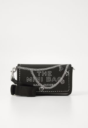 Mini borsa nera testurizzata con dettagli in catena, scritte bianche e tracolla regolabile. Presenta design grafici e dettagli di cucitura a contrasto.