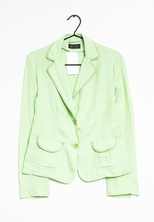 Blazer da donna verde chiaro con due tasche frontali, chiusura con un bottone e rifiniture decorative su collo e tasche, appeso a una gruccia nera.
