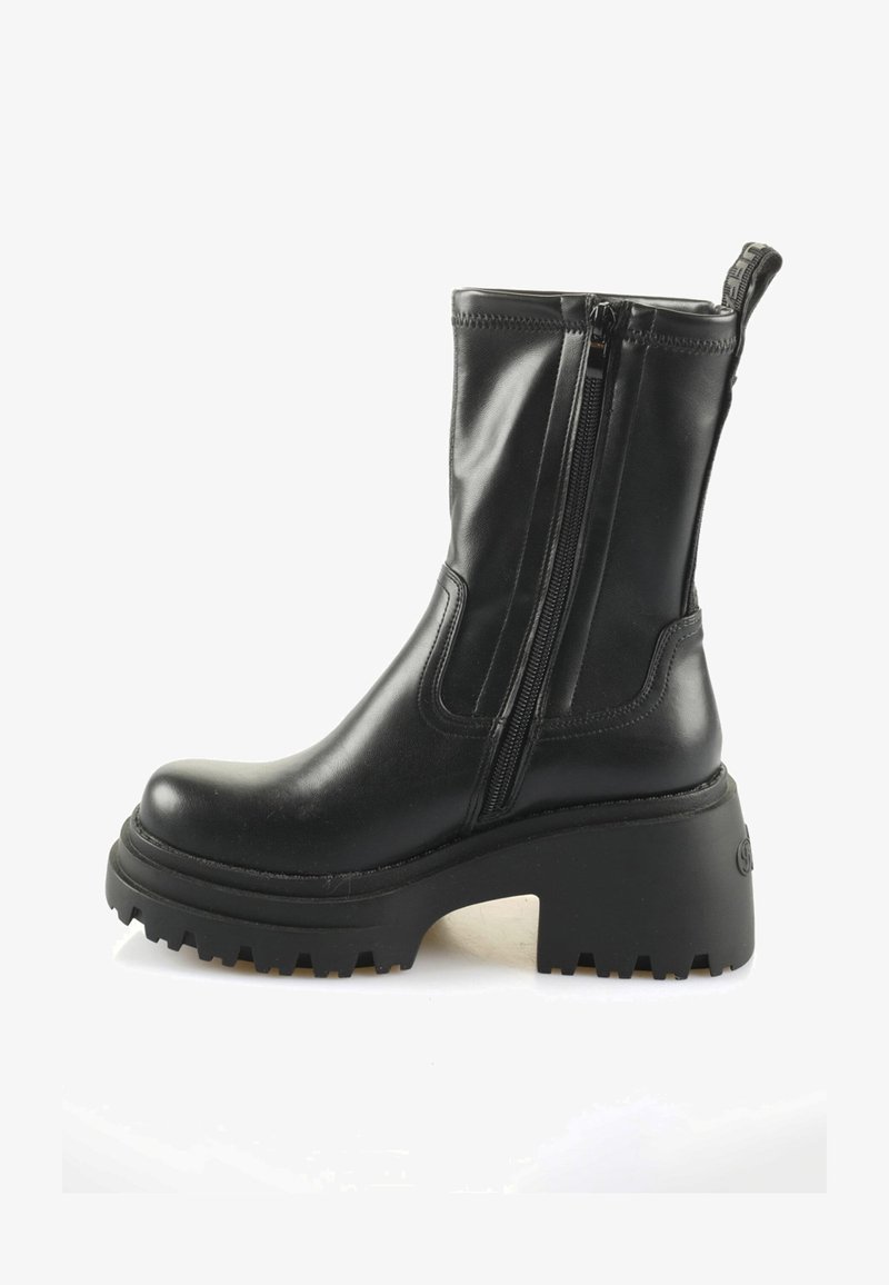 Čierne kožené kotníkové čižmy s dvojitými zipsami, robustnou medzipodrážkou a textúrovanou gumovou podrážkou. Obsahujú pútko na zadnej strane pre jednoduché obutie.