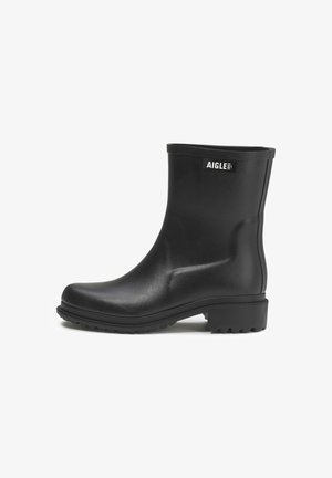 Black rubber ankle boots with a smooth texture, rounded toe, and grooved sole. Features a logo label on the outer side.