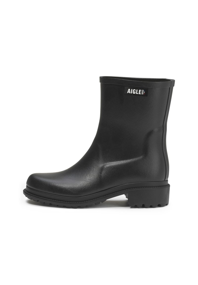 Black rubber ankle boots with a smooth texture, rounded toe, and grooved sole. Features a logo label on the outer side.