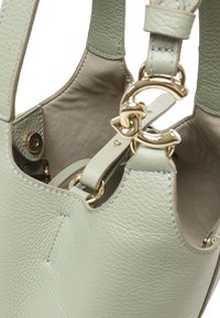 Borsa a mano in pelle verde con superficie testurizzata, ferramenta dorata e tracolla staccabile. Interno liscio con un unico scomparto.