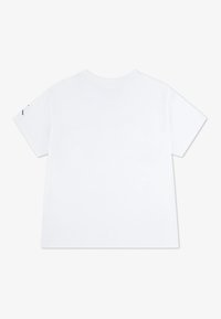 Camiseta blanca de manga corta hecha de algodón con una textura suave, que presenta un escote redondo y sin gráficos ni logotipos visibles en la parte posterior.