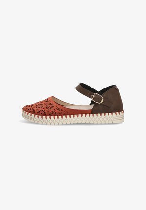Zapato plano con parte delantera naranja con patrones florales cortados con láser, tacón marrón, suela beige con costuras y correa marrón en el tobillo con hebilla dorada.