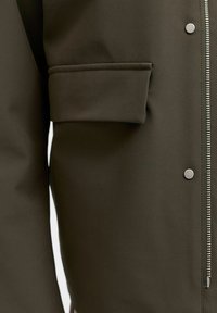 Temno zelena jakna z zadrgo, gumbki na pritisk in stranskim žepom, z gladko teksturo in mat zaključkom.