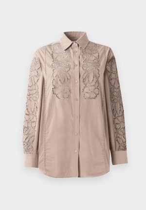 Lys beige knappskjorte med intrikate blonder-lignende blomsterbroderier på ermmene. Mykt stoff med strukturert krage og lange ermer.