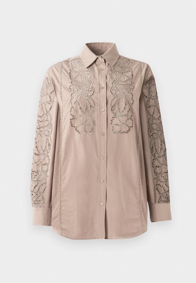 Light beige button-up shirt with intricate lace-like floral embroidery on sleeves. Soft fabric with structured collar and long sleeves.