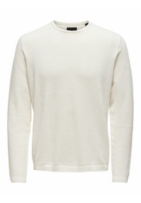 Sweat-shirt à manches longues de couleur crème avec un design texturé en maille gaufrée, poignets côtelés et encolure ronde. Simple et polyvalent.