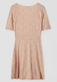 Robe beige à manches courtes avec petit imprimé floral blanc, taille cintrée et jupe évasée sur fond uni clair.