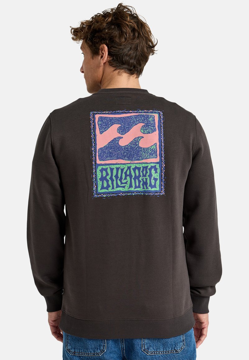 Sudadera marrón con puños y dobladillo acanalados. La parte posterior presenta un diseño gráfico colorido con patrones de olas y el nombre de la marca "BILLABONG."