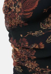 Tkanina w kwiaty z dużymi pomarańczowymi i brązowymi kwiatami na czarnym tle. Tekstura jest gładka, z marszczonymi fragmentami.