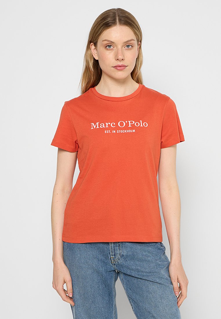 Oranges T-Shirt mit kurzen Ärmeln aus Baumwolle und rundem Ausschnitt. Auf der Vorderseite steht in weißen Buchstaben "Marc O’Polo EST. IN STOCKHOLM".
