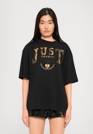 Svart oversized t-skjorte med gull- og sølvlogoen "JUST CAVALLI", med myk tekstur, rund hals og korte ermer.