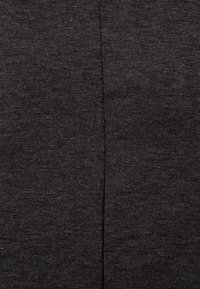 Tumma harmaa kangas, sileä rakenne, hieman kiiltävä, ja pystysauma keskellä, joka luo tasaisen ilmeen.