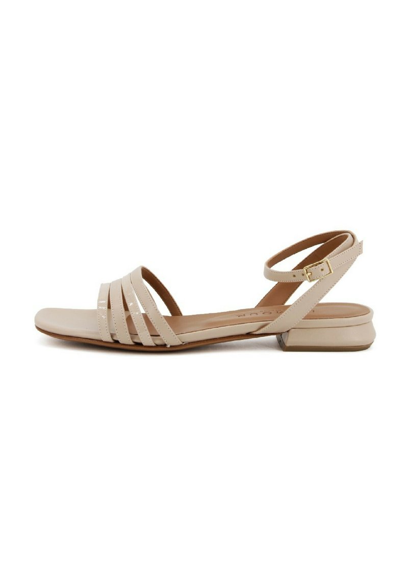 Sandali piatti beige con più cinturini sottili, punta rotonda, cinturino alla caviglia con fibbia e tacco basso e supporto. Finitura liscia.