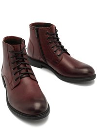 Burgundzkie skórzane botki do kostki o gładkim wykończeniu, z zapięciem na sznurówki i bocznym zamkiem błyskawicznym, czarna gumowa podeszwa oraz bez widocznych wzorów czy akcentów.