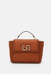Hnědá texturovaná kožená kabelka s horním držadlem, zlatými doplňky a přední klopnou s logem "CK" v zlaté barvě. Obdélníkový design.