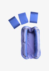 Sac à déjeuner isotherme bleu ouvert à plat avec trois pochettes détachables bleues à velcro disposées au-dessus sur un fond blanc.