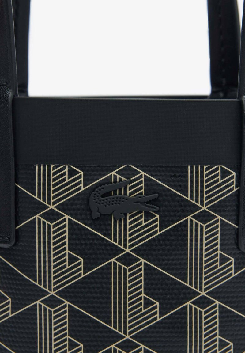 Sac à main noir avec un motif géométrique doré, surface texturée et un accent logo crocodile noir à l'avant.