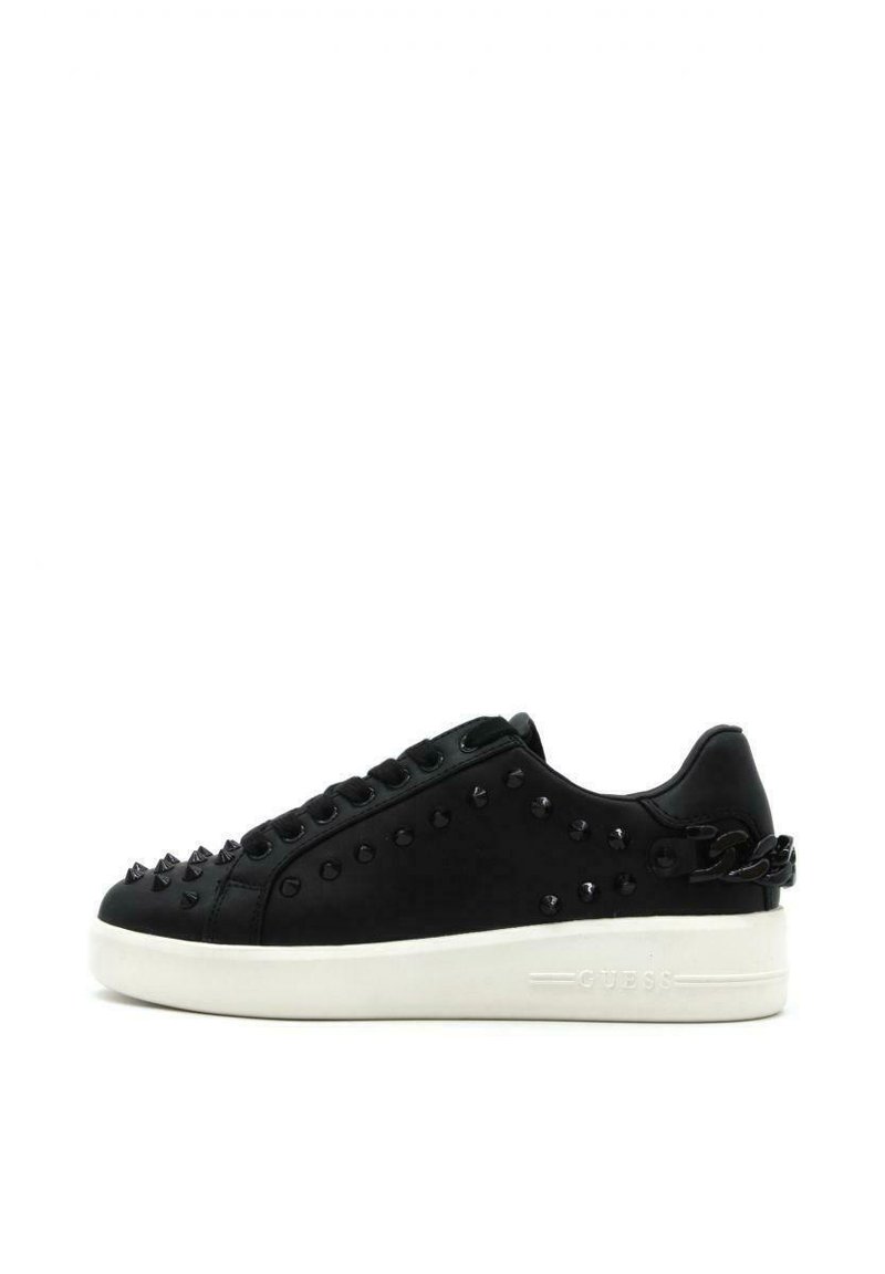 Sneaker nera con accenti borchiati, parte superiore in pelle liscia, suola in gomma bianca, design con lacci e dettaglio della catena laterale. Logo del brand sul tallone.