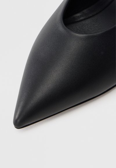 Μαύρο παπούτσι με μυτερή μύτη από λείο δέρμα με κομψό σχεδιασμό. Διαθέτ ει μινιμαλιστική εμφάνιση και χαμηλή κοπή στο μπροστινό μέρος για μια εκλεπτυσμένη όψη.