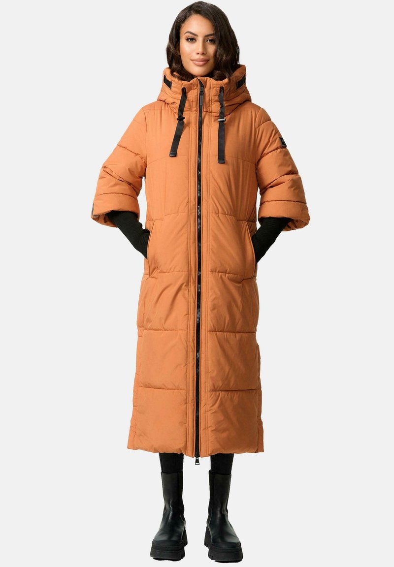 Lange oranje pufferjas met een hoge kraag, ritssluiting aan de voorkant en zwarte accenten. Heeft brede mouwen en een geborduurd textuur, gecombineerd met zwarte laarzen.