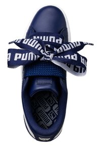 Navy leather sneaker with a textured fabric tongue. Features wide logo-patterned laces and a patterned insole. Clean white rubber sole.