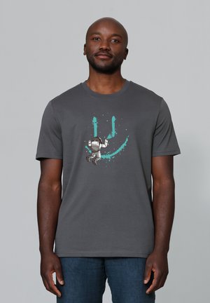 Grijze t-shirt met korte mouwen met een astronautenafbeelding en teal spetteraccenten aan de voorkant. Gemaakt van een zachte, ademende stof.