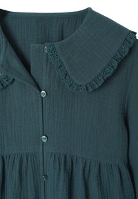 Dark teal textured fabric blouse with ruffled lace-trimmed Peter Pan collar and a front button closure.
