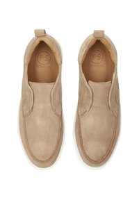 Zapatos de ante de color marrón claro, tipo slip-on, con paneles laterales elásticos, punta redondeada, suela de goma blanca y logo de la marca grabado en el interior.