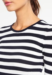 Marineblauw en witte gestreepte ribgebreide top met een ronde halslijn, een slim fit ontwerp en korte mouwen, die textuur en contrasterende kleuren laat zien.