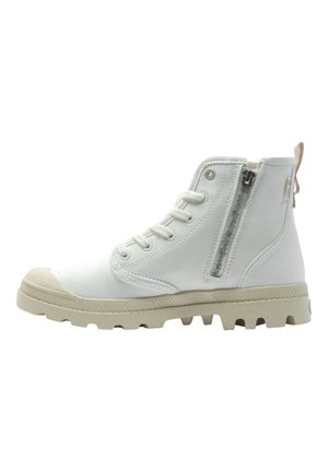 Botas de tobillo de lienzo blanco con suela de goma texturizada. Cuenta con un cierre lateral con cremallera y una parte frontal con cordones. Punta redondeada y puntera reforzada.