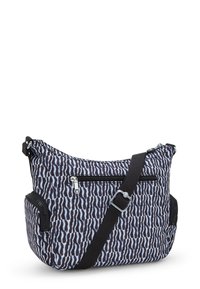 Slingväska i svart och vitt zebramönstrat tyg, med flera zippered fack, justerbar rem och slitstark tygtextur.