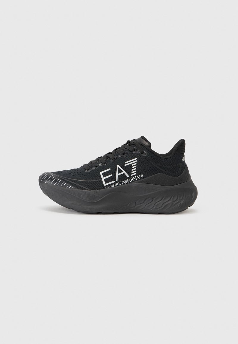 Fekete sportcipő textált hálós felsőrésszel, párnázott bokarésszel és vastag, hullámos gumitalppal. Feltűnő "EA7" felirat ezüst színben.