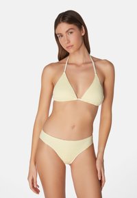 Geel gestructureerd bikini met een driehoekige top en bijpassende low-rise slipjes. Het materiaal lijkt zacht te zijn met een subtiel patroon en verstelbare bandjes.