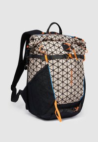 Zaino con motivo geometrico in beige e nero. Include accenti arancioni, cinghie regolabili e più tasche. Materiale strutturato.