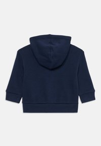 Felpa per bambino di colore blu scuro, con maniche lunghe, polsini e vita a coste, vista da dietro su uno sfondo bianco.