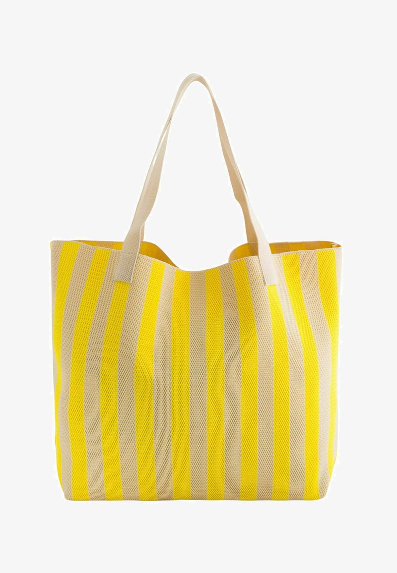 Bolso de mano a rayas que presenta material de malla amarillo y beige, con dos asas resistentes y una apertura espaciosa en la parte superior.