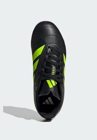 Scarpa da rugby nera con strisce verde brillante, tomaia in pelle, punta rotonda, colletto imbottito e lacci neri. Include il logo sulla linguetta.
