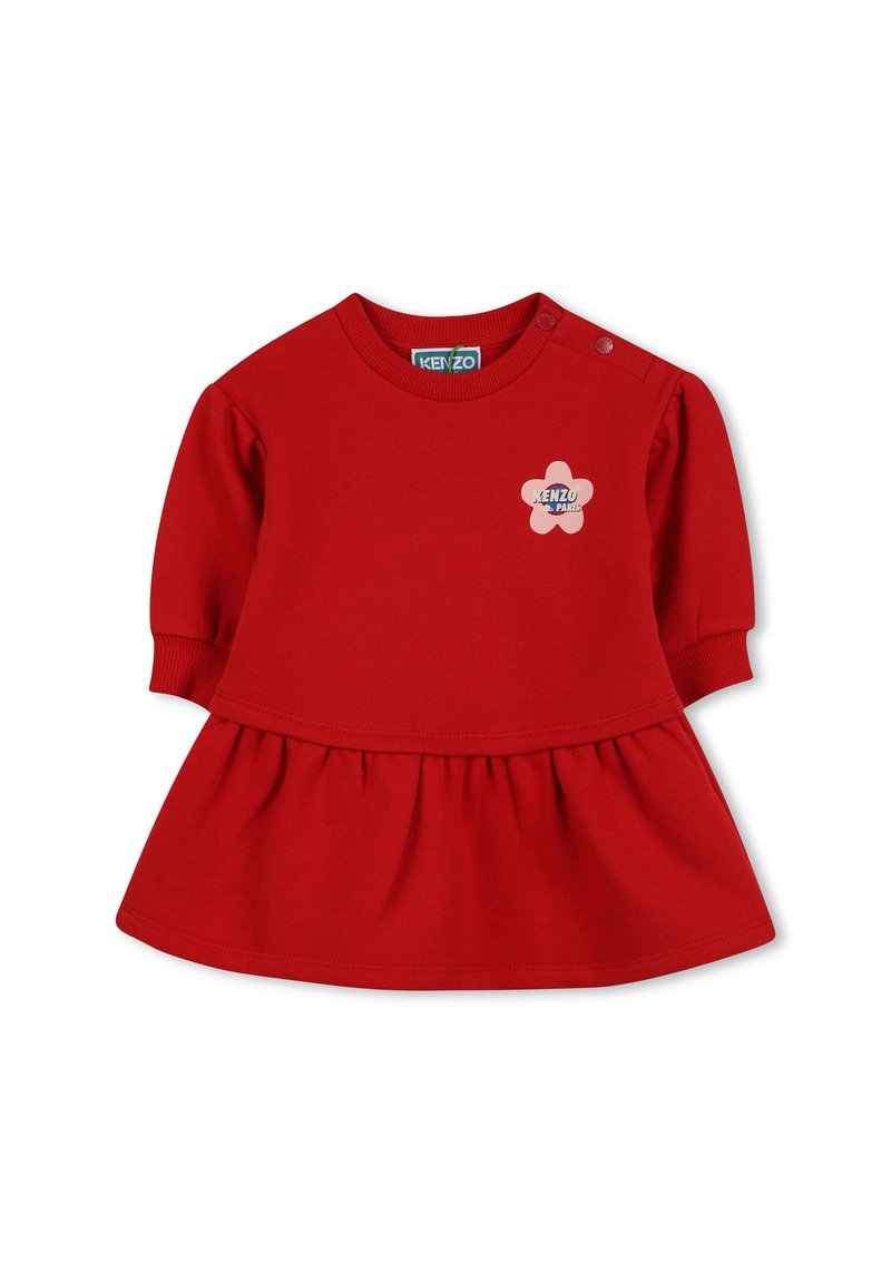 Czerwona bawełniana sukienka z okrągłym dekoltem, krótkimi bufkami i rozkloszowanym dołem. Posiada kwiatowy emblemat na piersi oraz guziki na ramieniu.